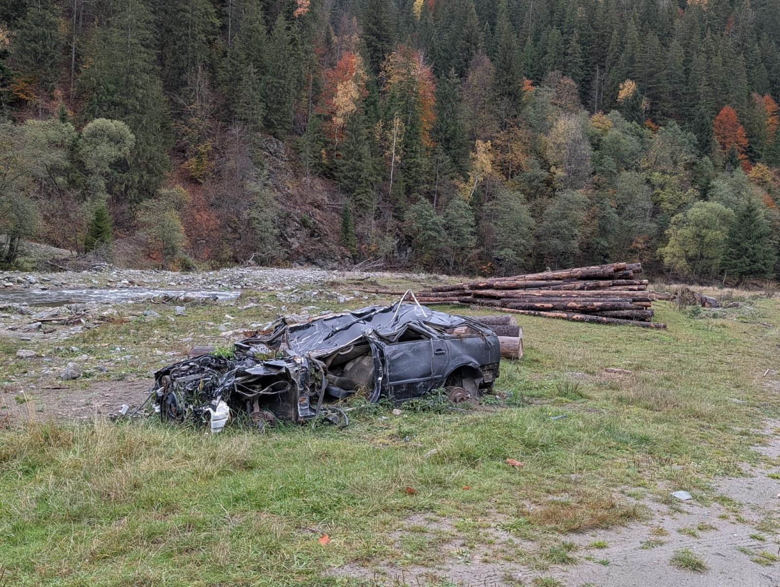 Dacă ai vedea doar caroseria abandonată a mașinii, ai zice că zona e părăsită. Stiva de lemne din spatele ei infirmă, însă, prima impresie